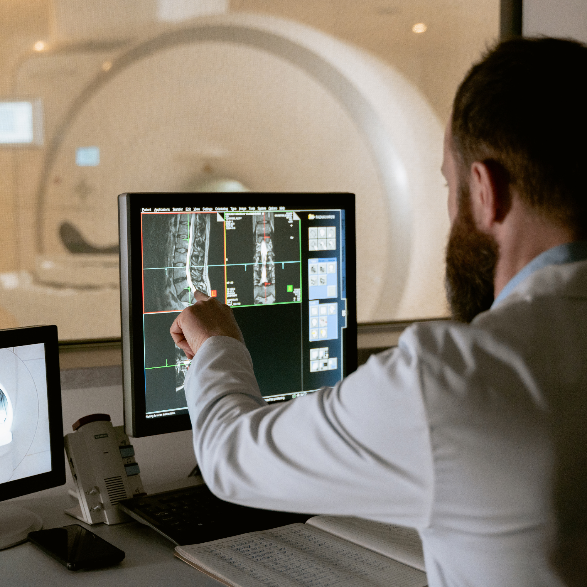Medical radiation technologist standing beside imaging equipment